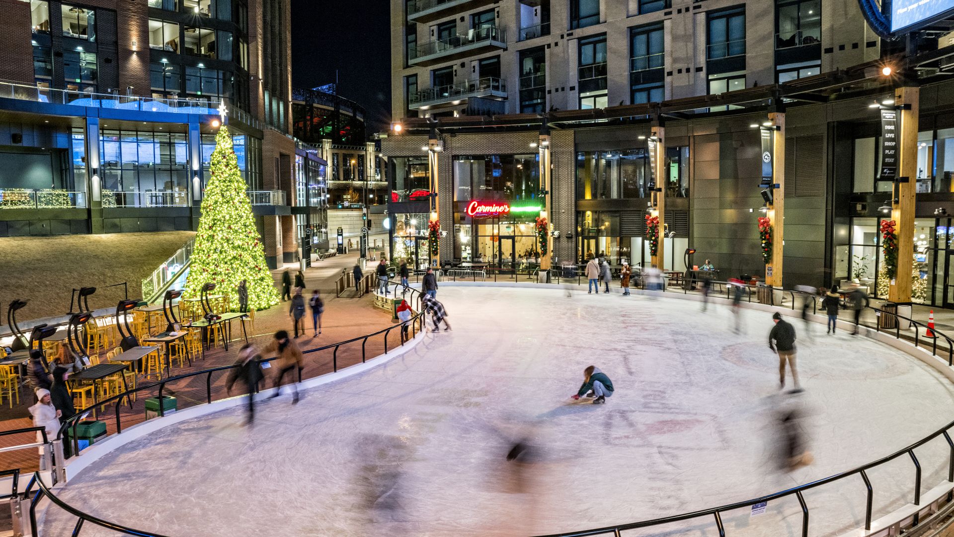 A Group Of People Playing In A Plaza With A Christmas Tree