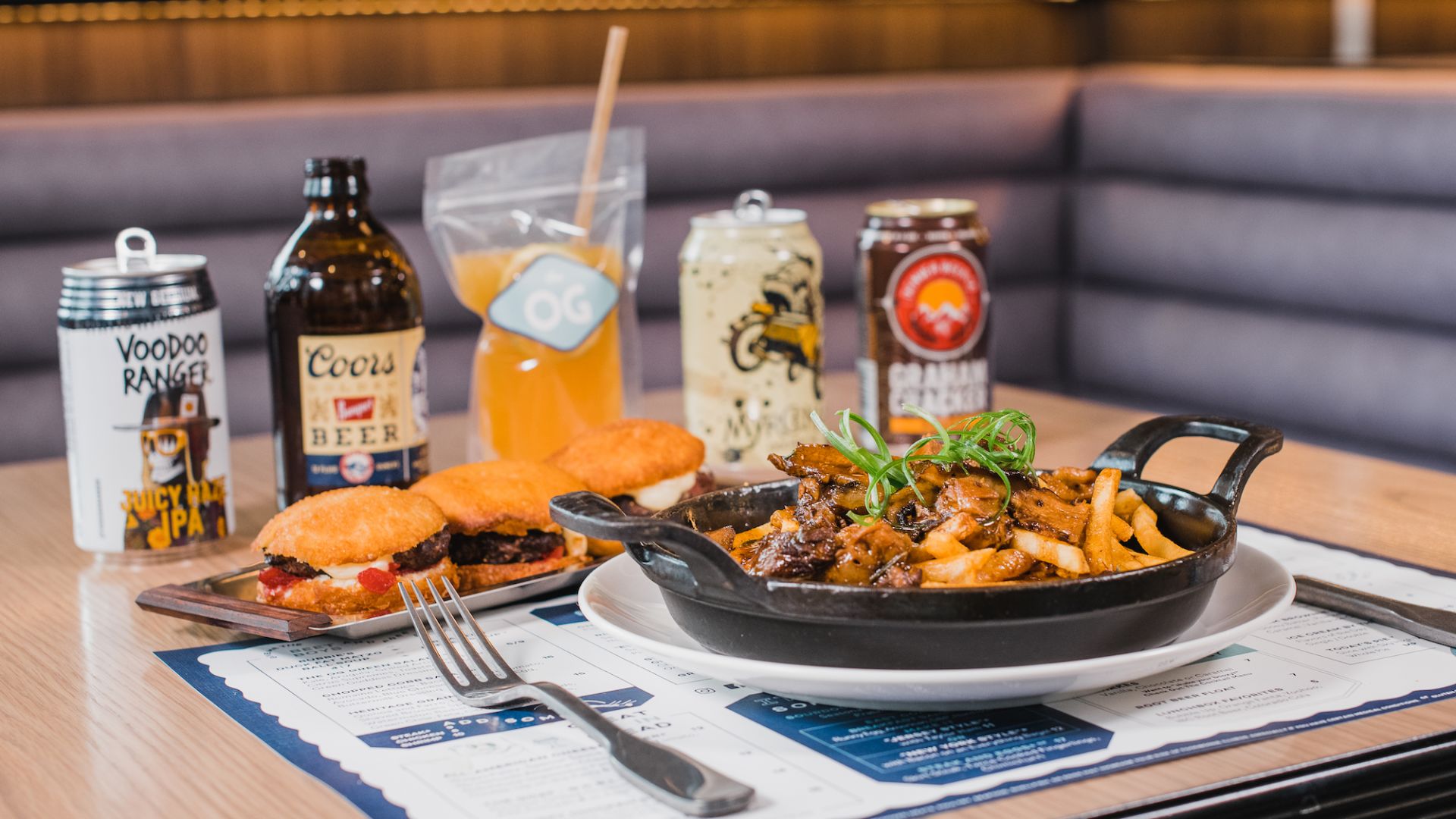 A Plate Of Poutine, Croughnut Sliders and Beverage Options On A Table
