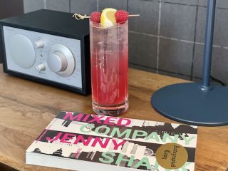 A Book and A Cocktail on a Bedside Table