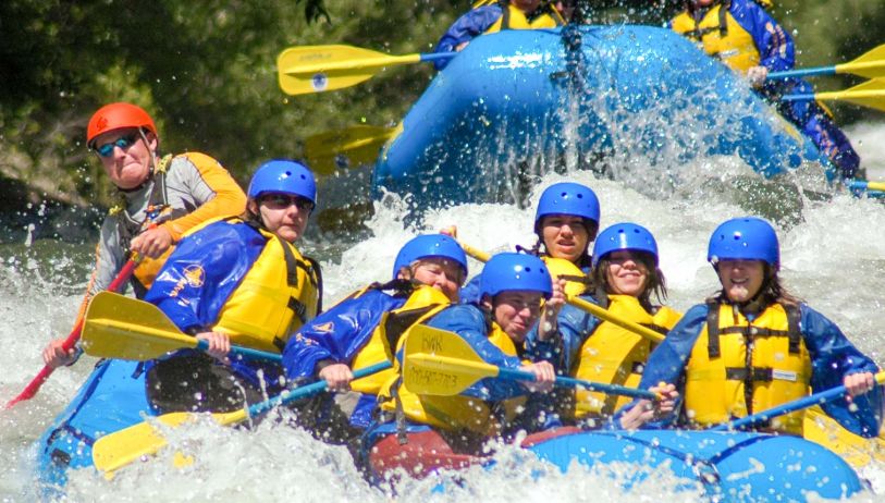 A Group Of People Riding Skis On A Raft